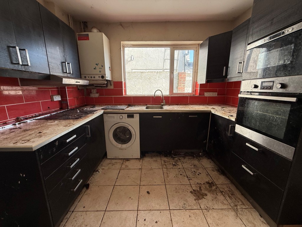 Lot: 173 - THREE-BEDROOM TERRACED HOUSE FOR REFURBISHMENT LOCATED IN A CUL-DE-SAC - Kitchen showing appliances with window and boiler